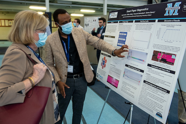 UMaine President, Joan Ferrini-Mundy, listens to a student talk about his poster at UMSS22
